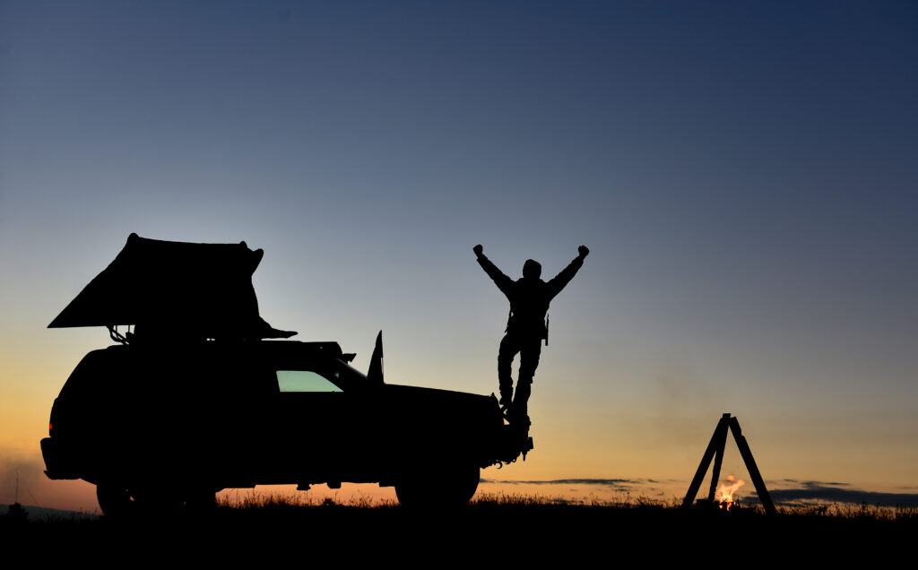 Bei Sonnenuntergang steht ein Camper auf dem Auto